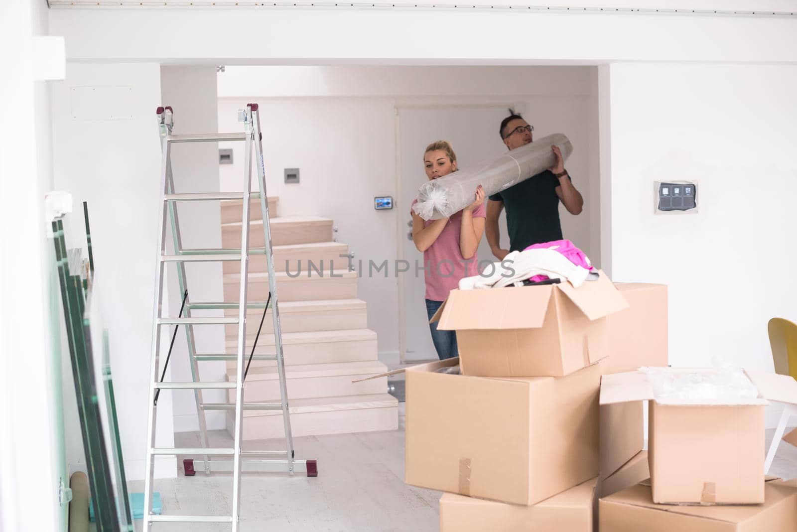 couple carrying a carpet moving in to new home by dotshock
