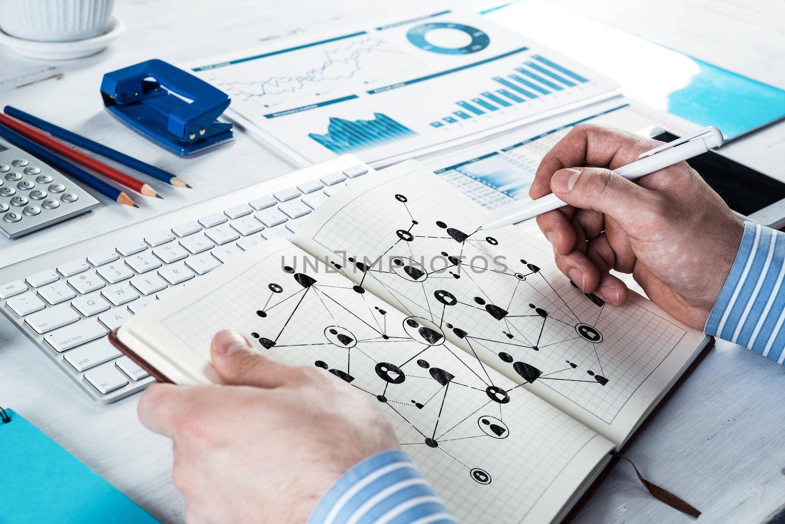 A man makes notes in a notebook. Draws social networks