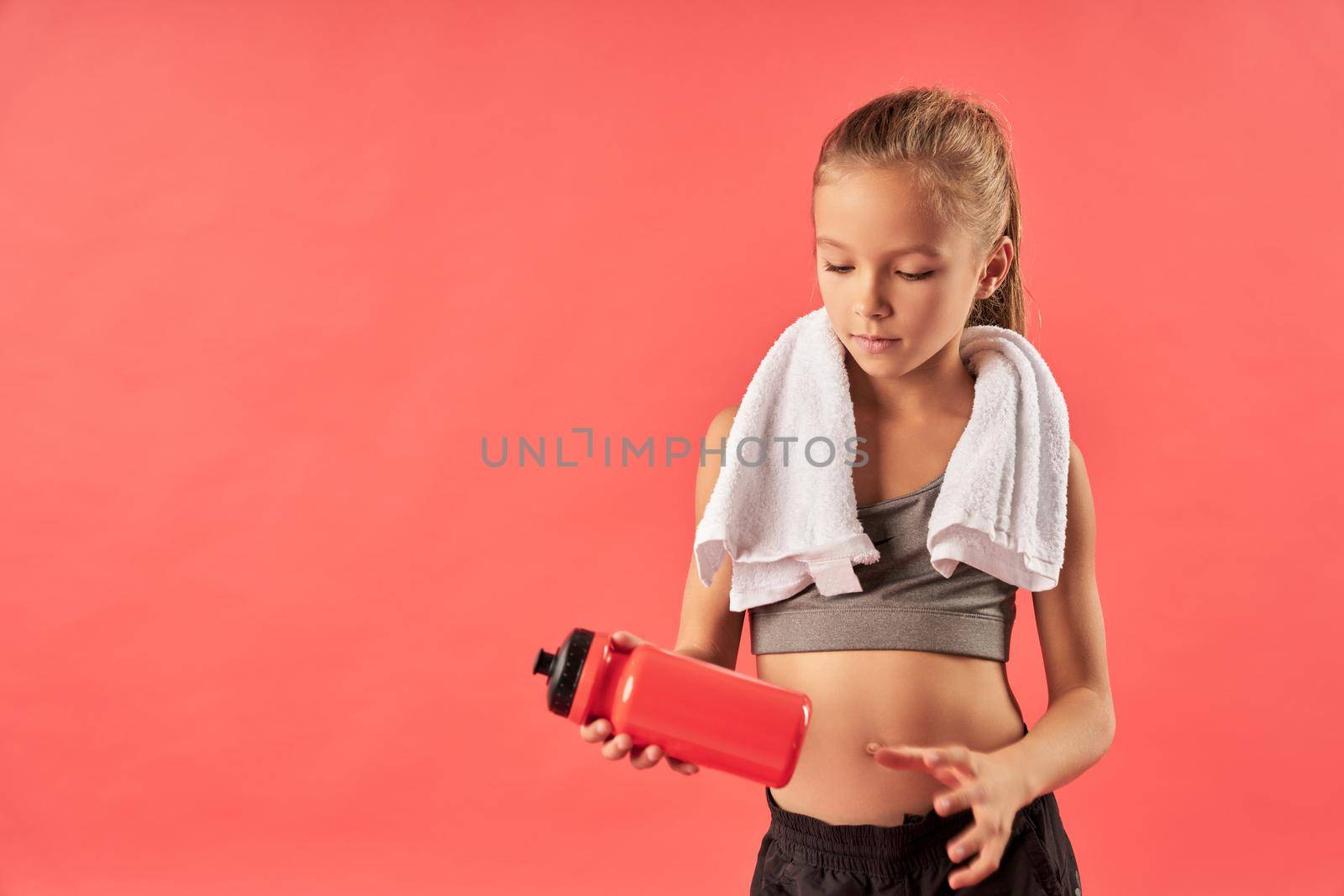 Cute sporty girl holding bottle of water by friendsstock