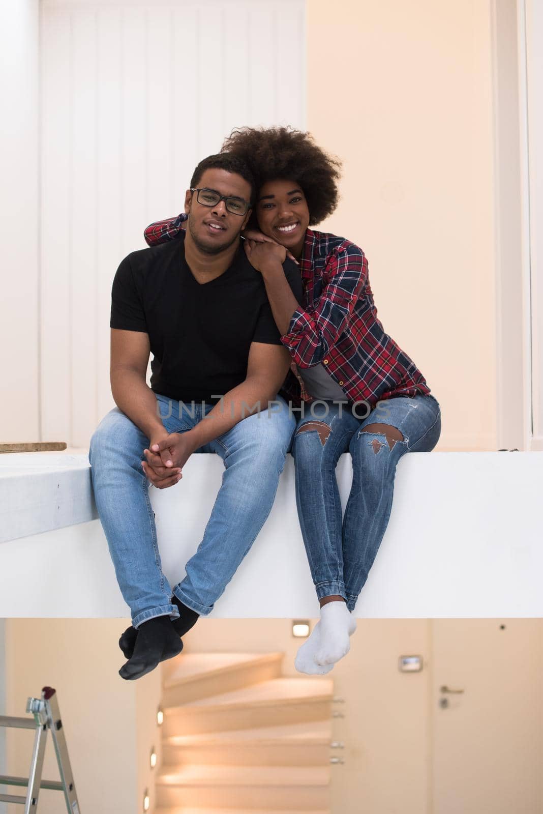 Happy young African American couple having break during moving to new house