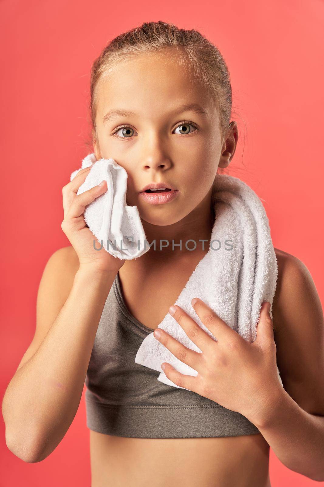 Adorable female child holding white soft towel by friendsstock
