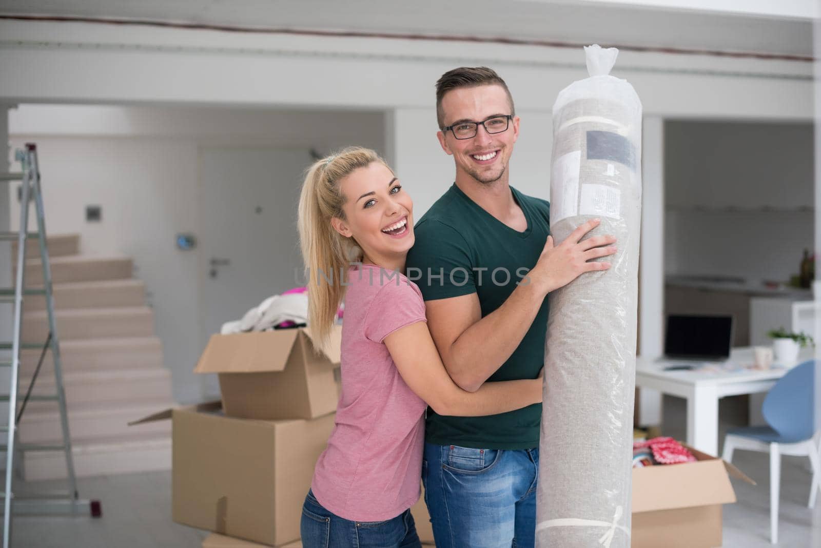 couple carrying a carpet moving in to new home by dotshock