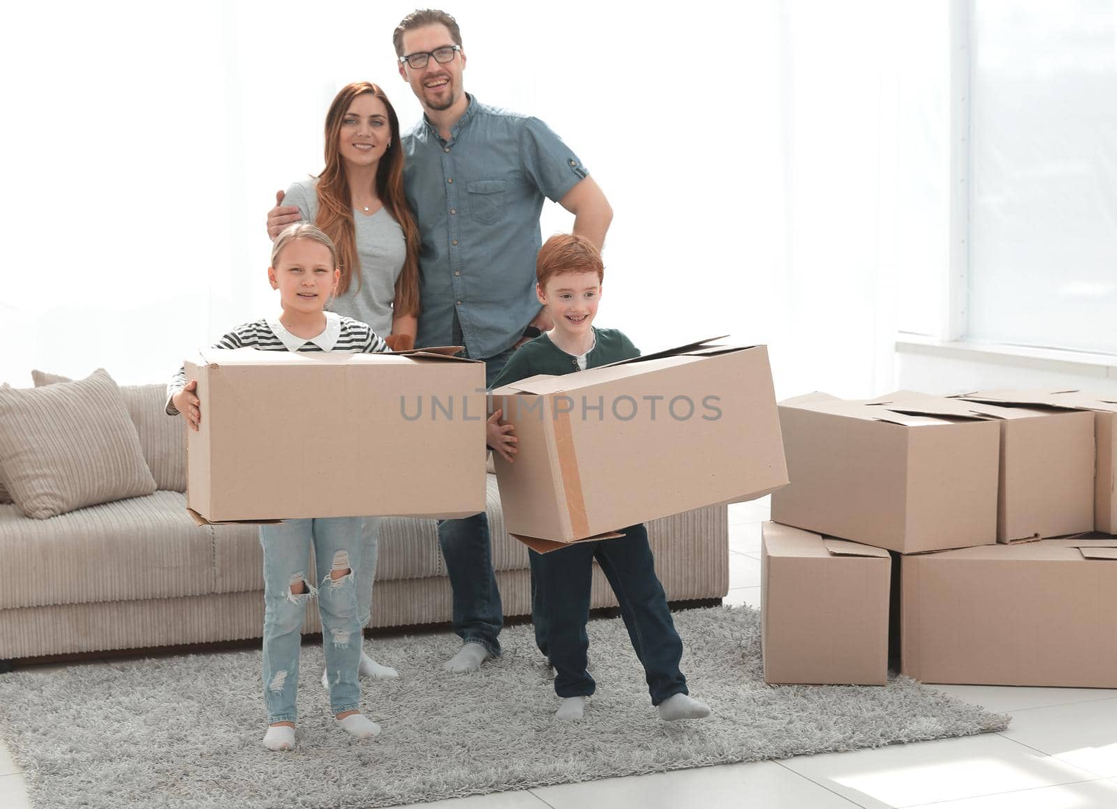 parents with their children moves the boxes to a new apartment by asdf