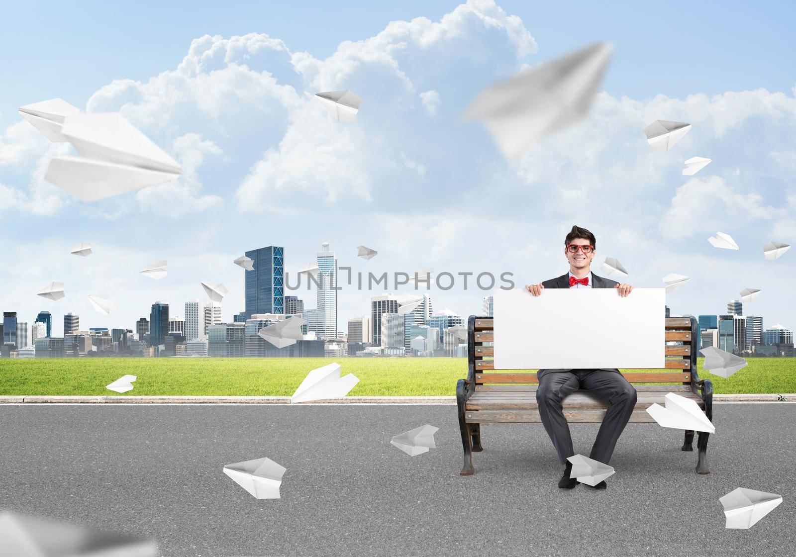 businessman with an empty banner. concept of creativity in business. around in the chaos flying paper plane