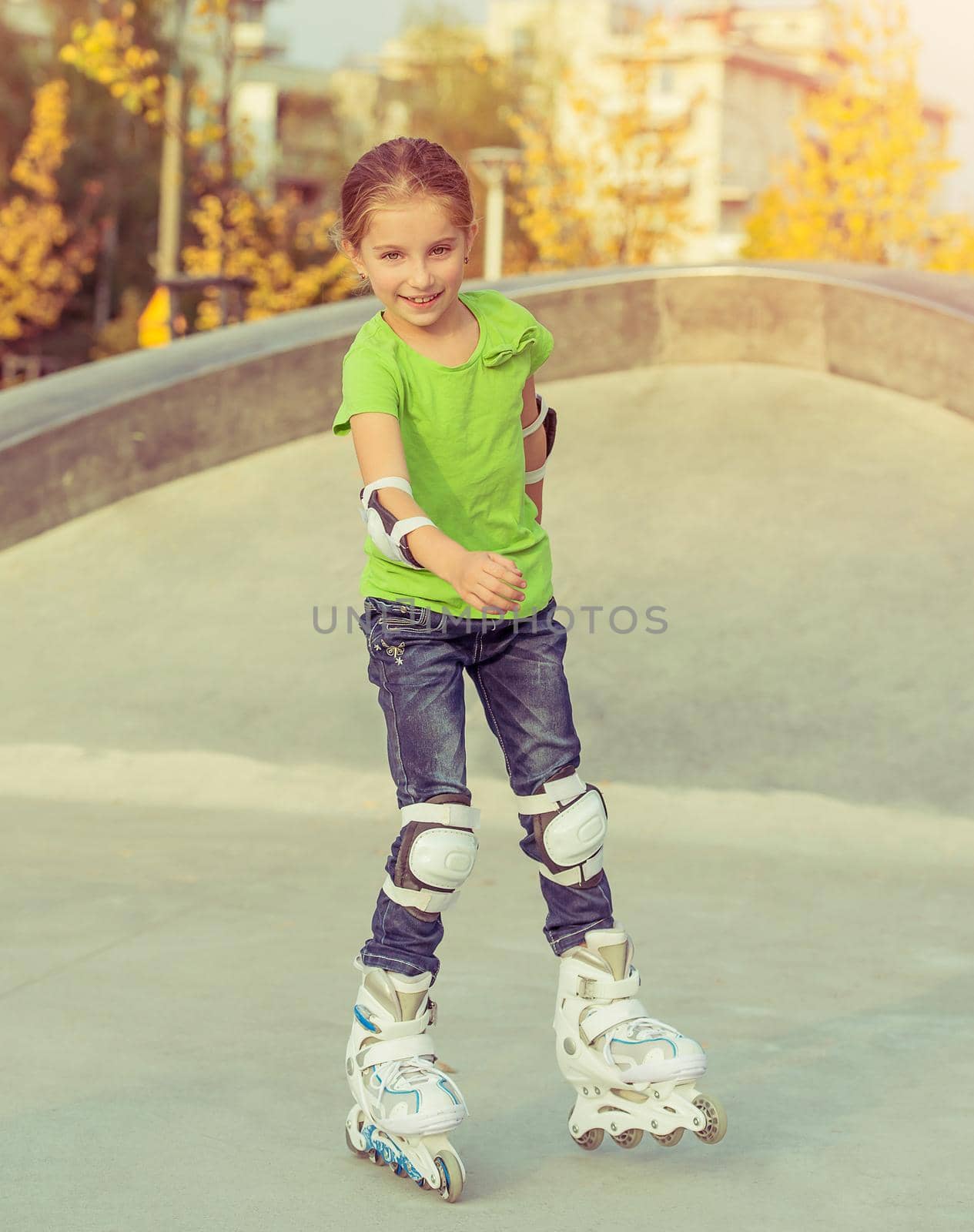 Cute little girl on roller skates at a park