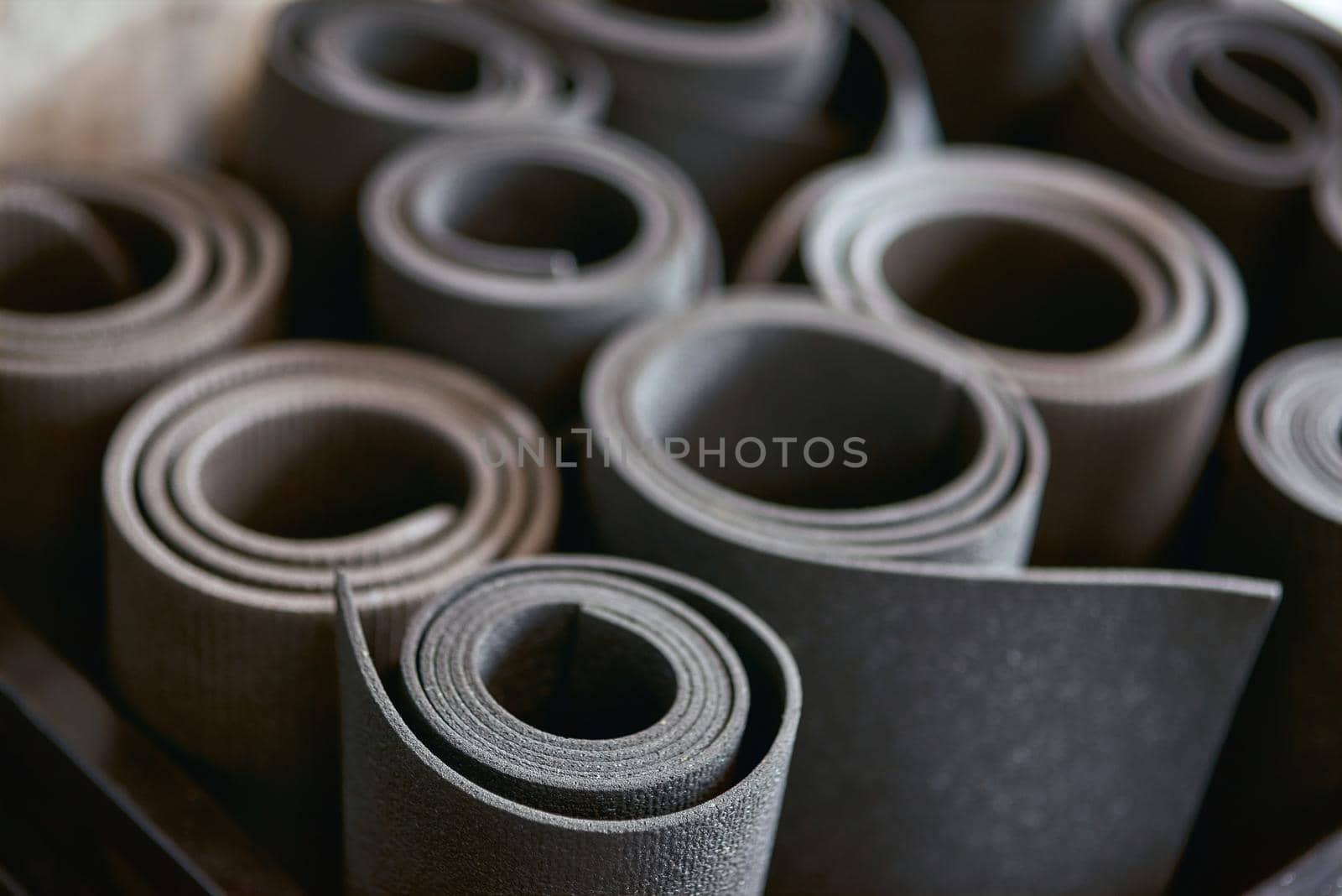 Fitness equipment. Rolled mats at gym, close up shot. Sport, yoga, pilates and healthy lifestyle concept