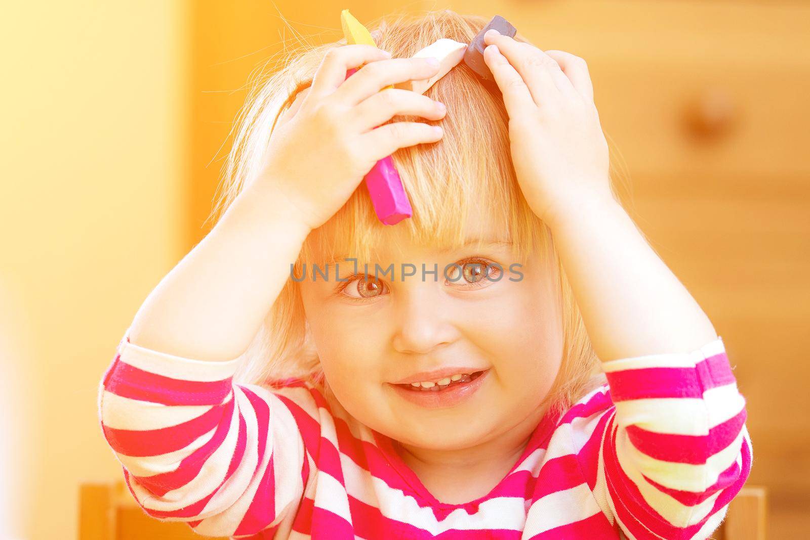 Cute girl playing with plasticine at home