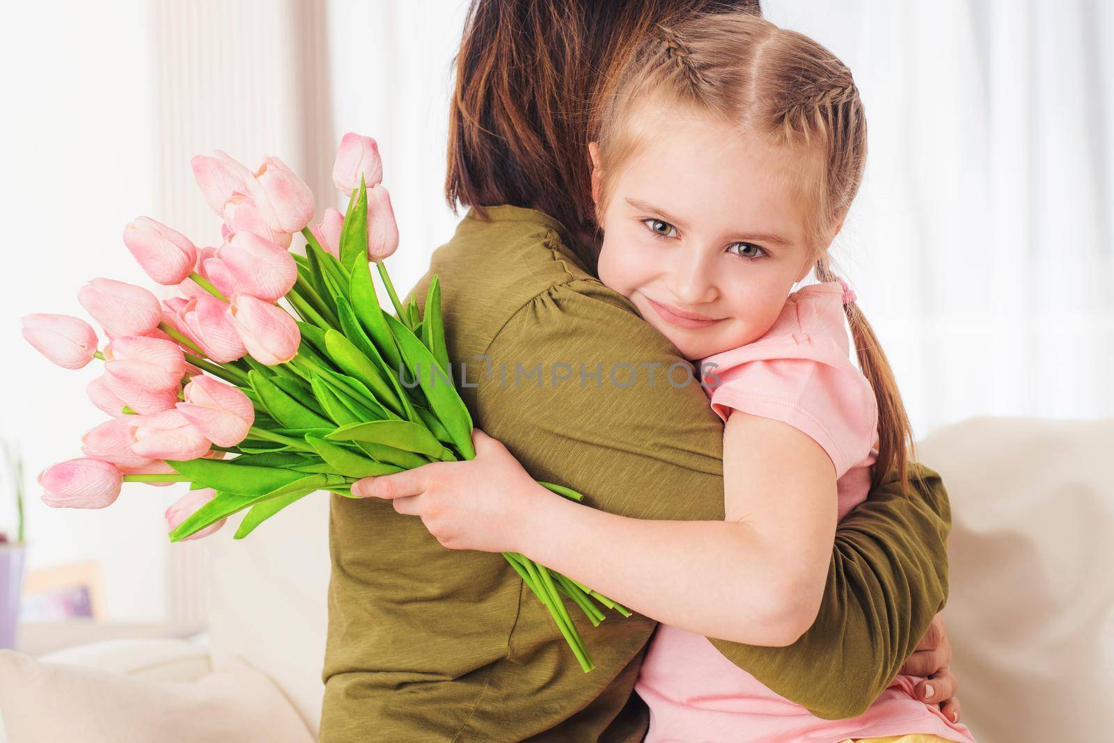 Cute kid embracing mother with festive bouquet, Mothers day