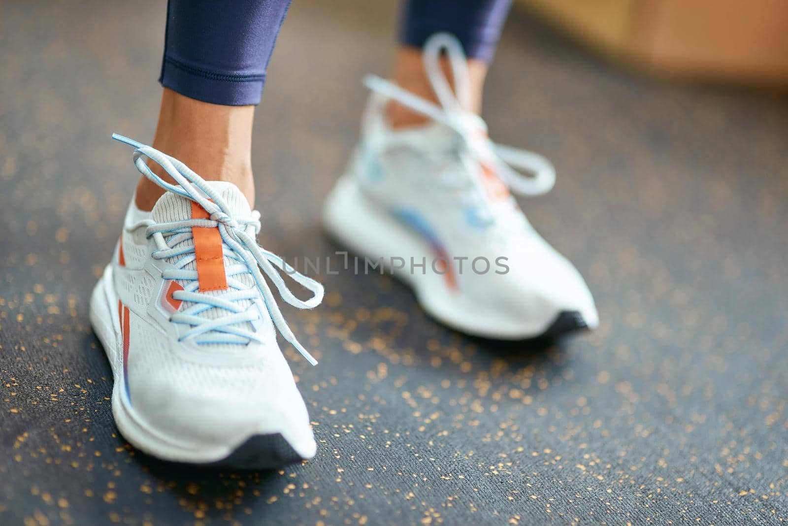 Cropped shot of female wearing sport shoes or sneakers standing at gym. Workout, training, healthy and active lifestyle concept