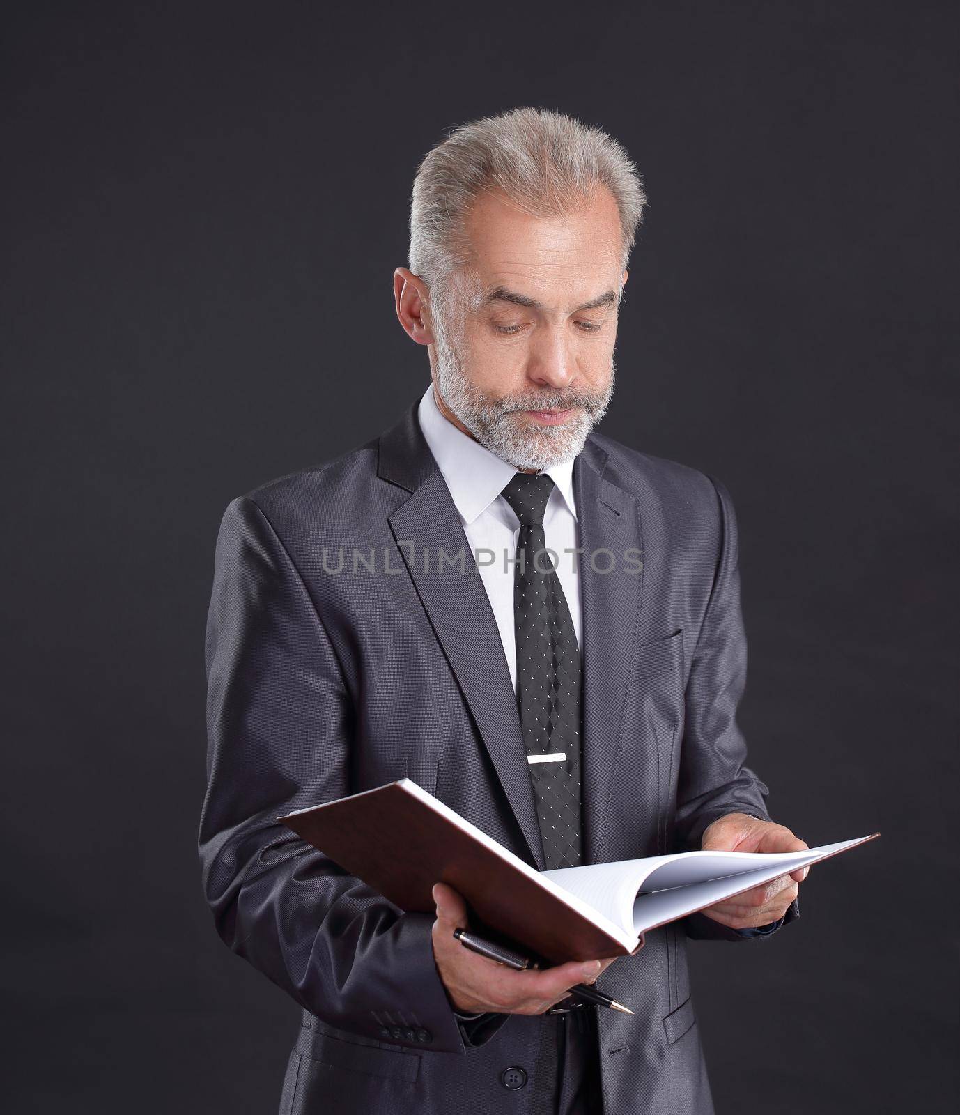 serious businessman signs a working document.isolated on black.