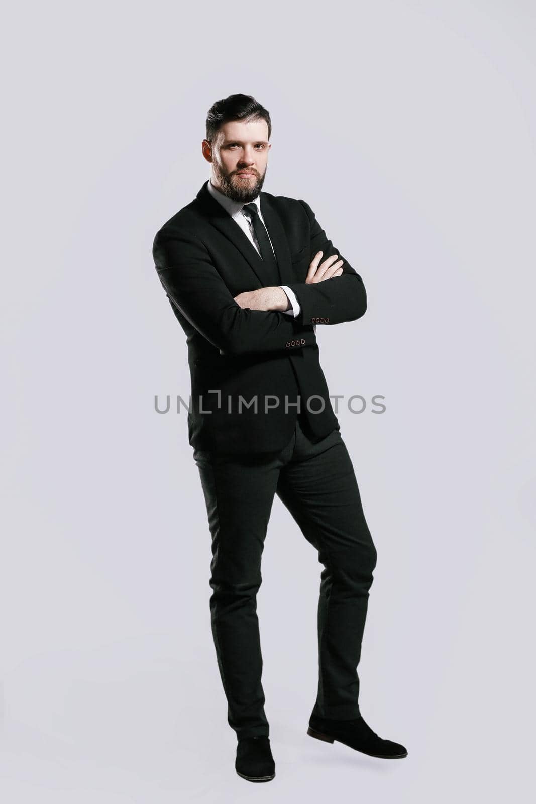 in full growth.portrait of a successful businessman.isolated on grey background.