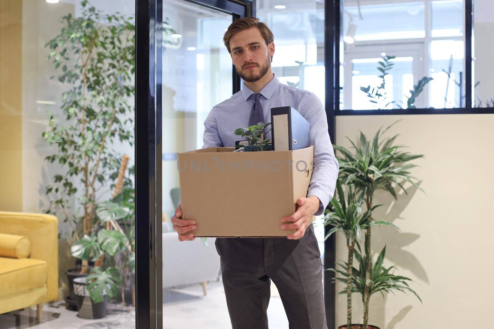 Dismissed worker going from the office with his office supplies