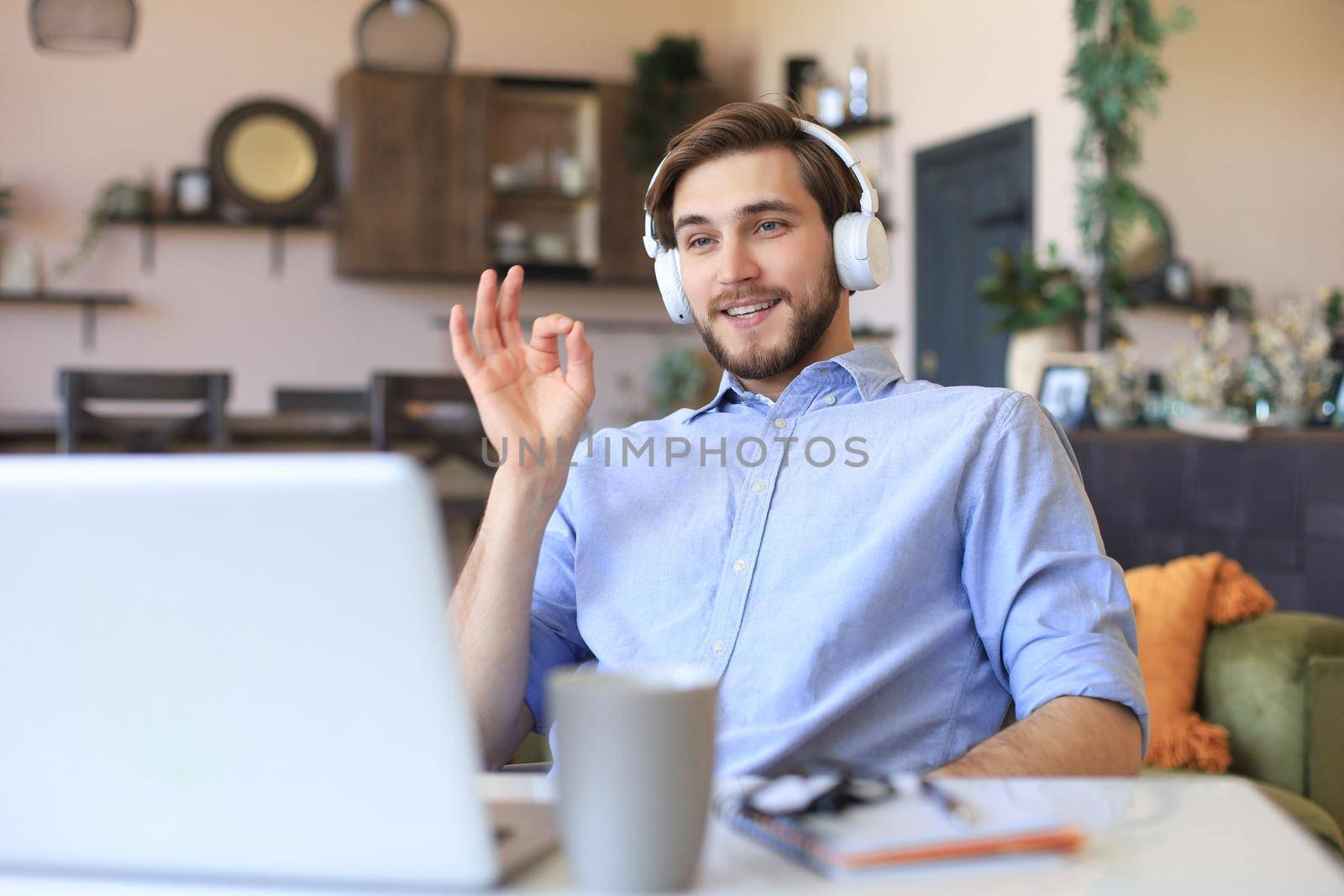 Happy young man in earphones working from home during self isolation