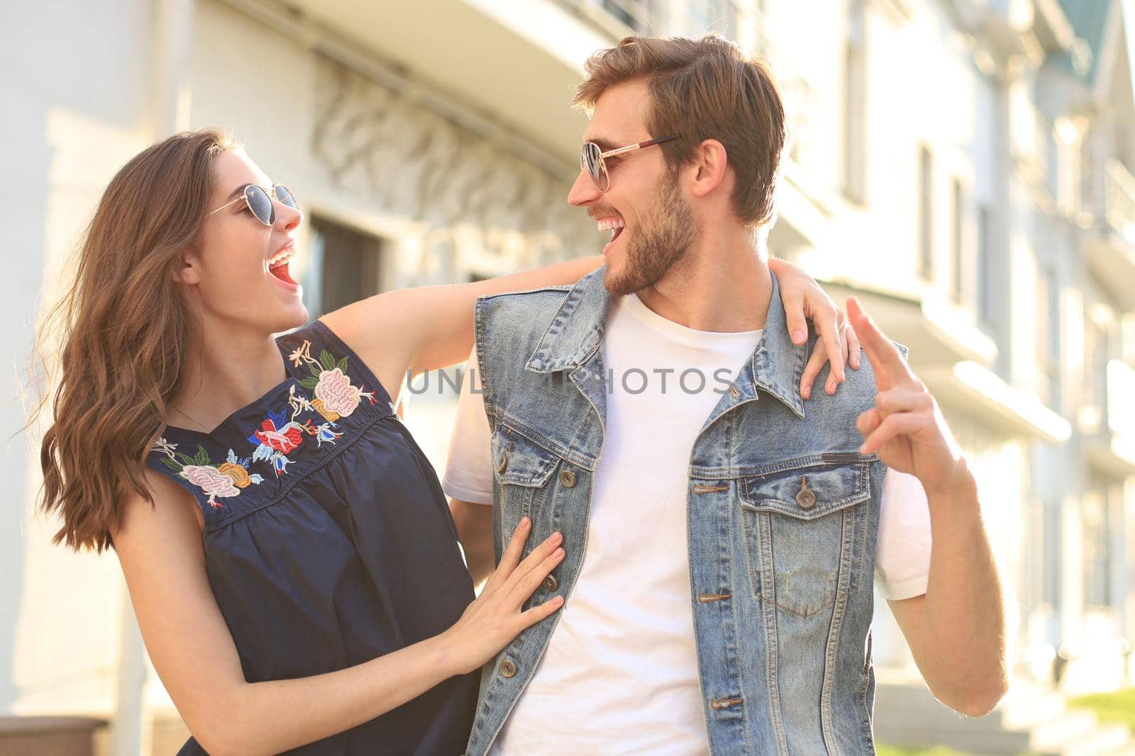 Beautiful young couple in love walking outdoors at the city street, hugging