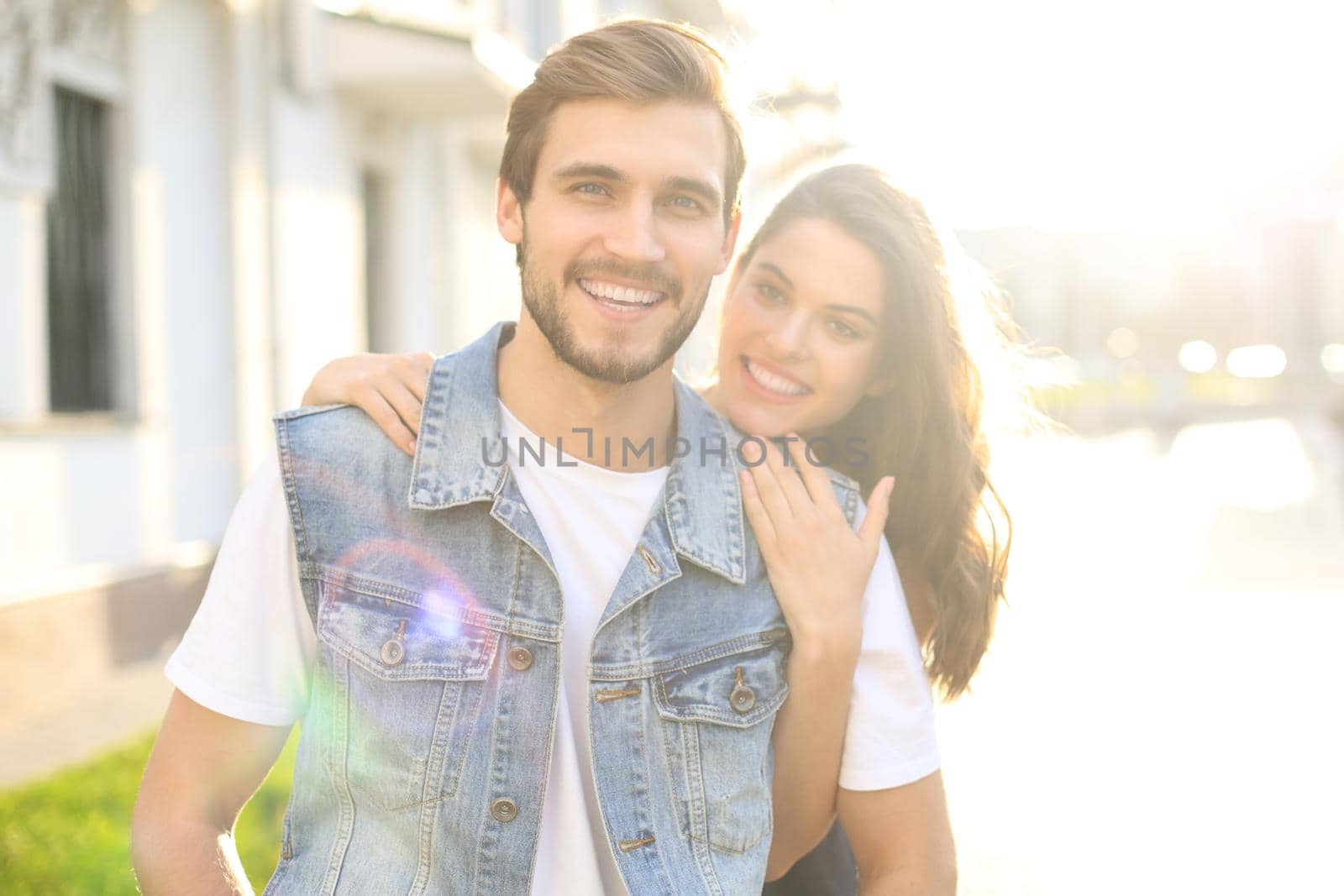 Beautiful young couple in love walking outdoors at the city street, hugging