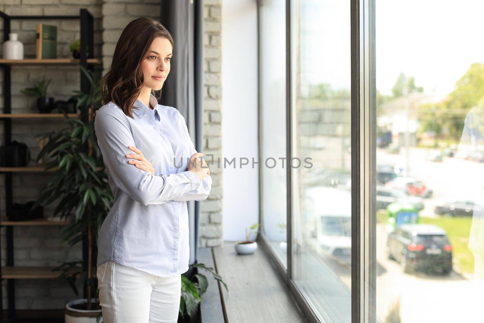 Cheerful woman student professional standing at home in office looking at camera