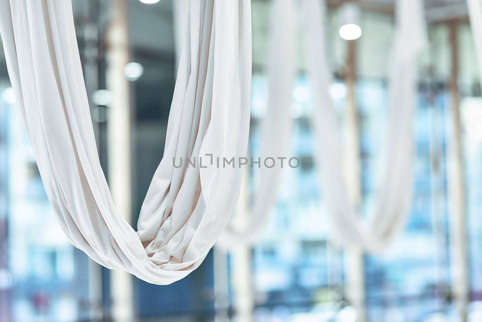 Close up shot of a white hammock for fly yoga in beautiful empty studio or gym by friendsstock