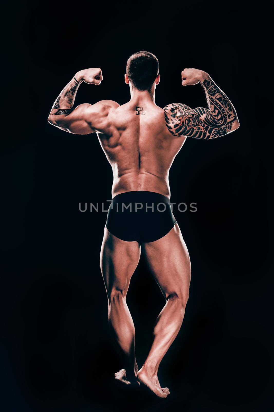 rear view. male bodybuilder showing his beautiful body.isolated on black background