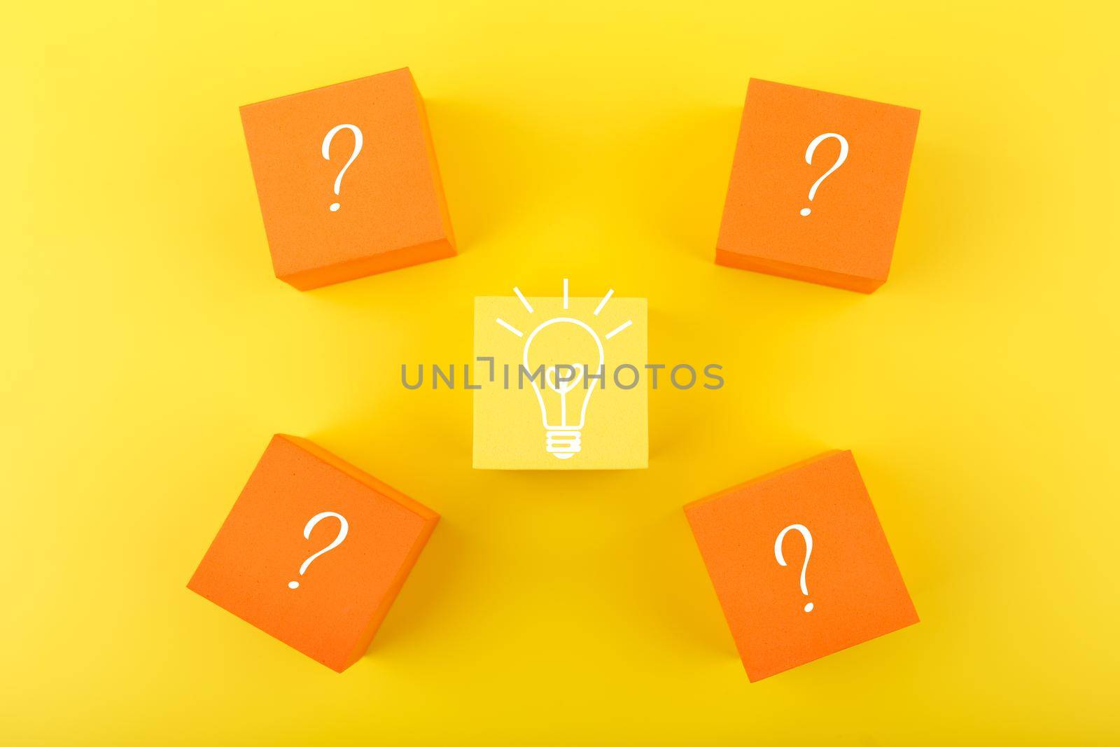 Creativity, innovation and idea concept. Flat lay with light bulb drawn on yellow cube and question signs on orange cubes by Senorina_Irina