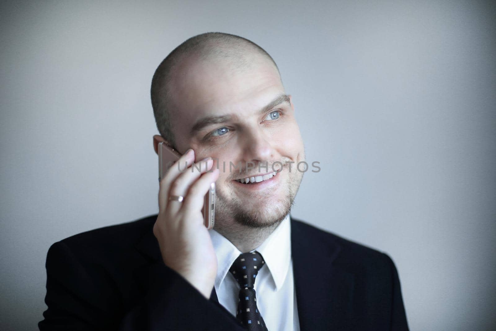 close up.confident businessman in a tie listens to the interlocutor on the phone.