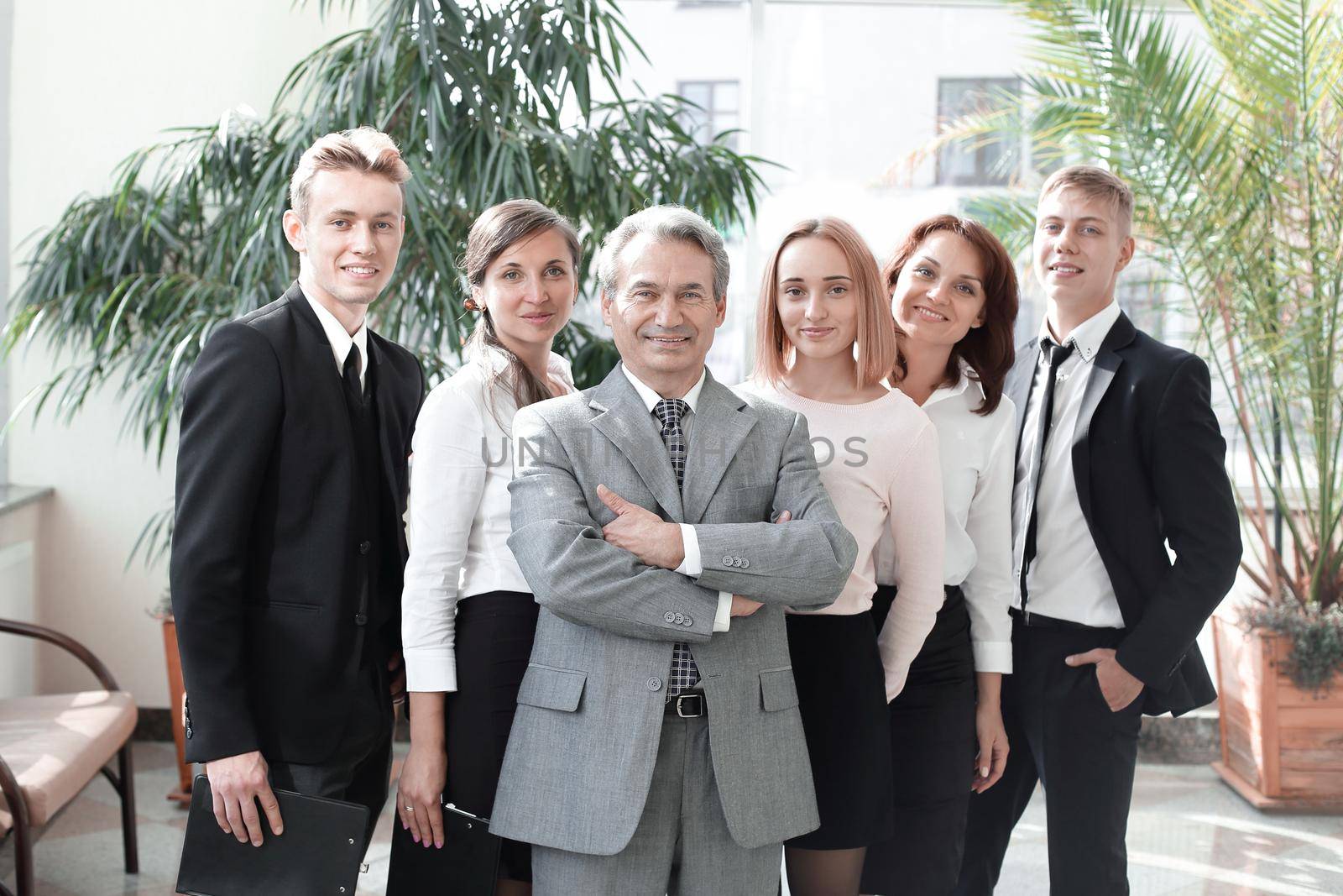 Successful business man standing with his staff in background at office.concept of teamwork
