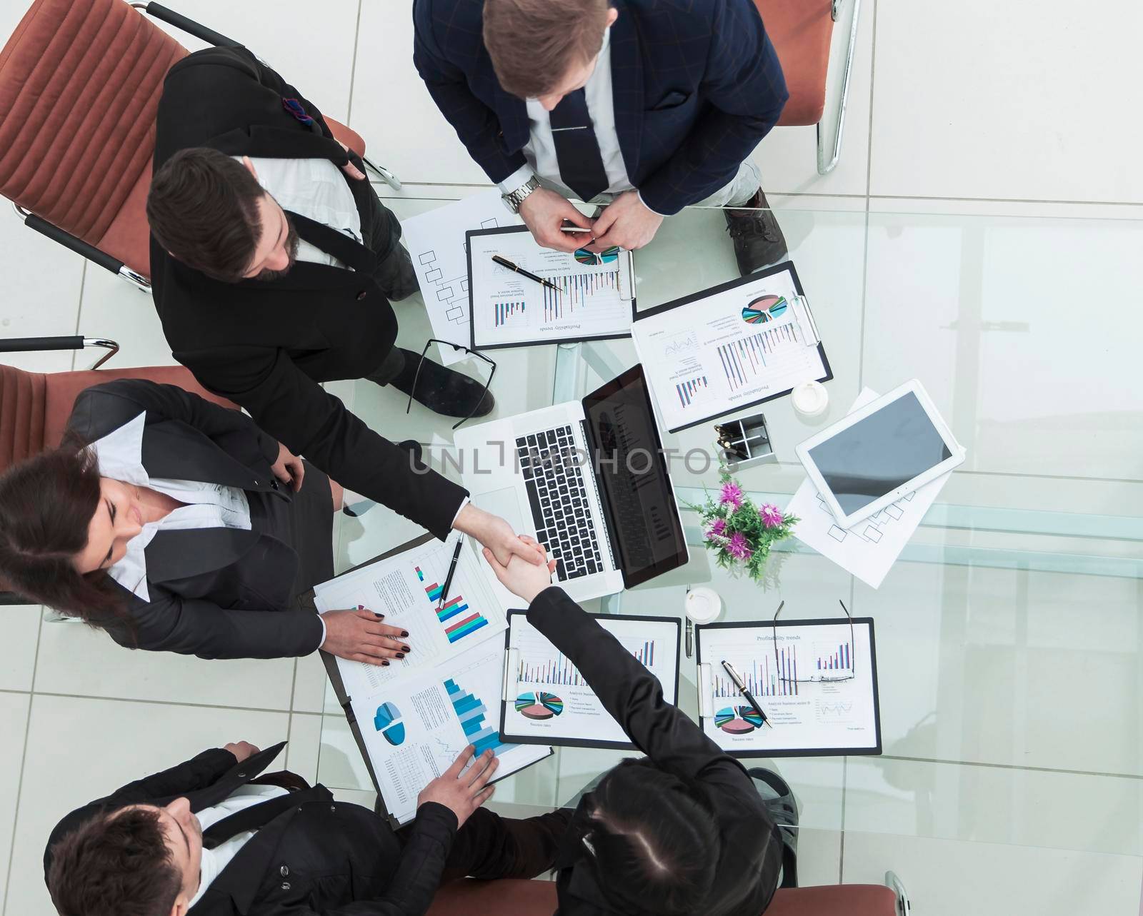 top view - handshake Manager and Finance Director after approval of the financial plan of the company in the workplace.the photo has a empty space for your text