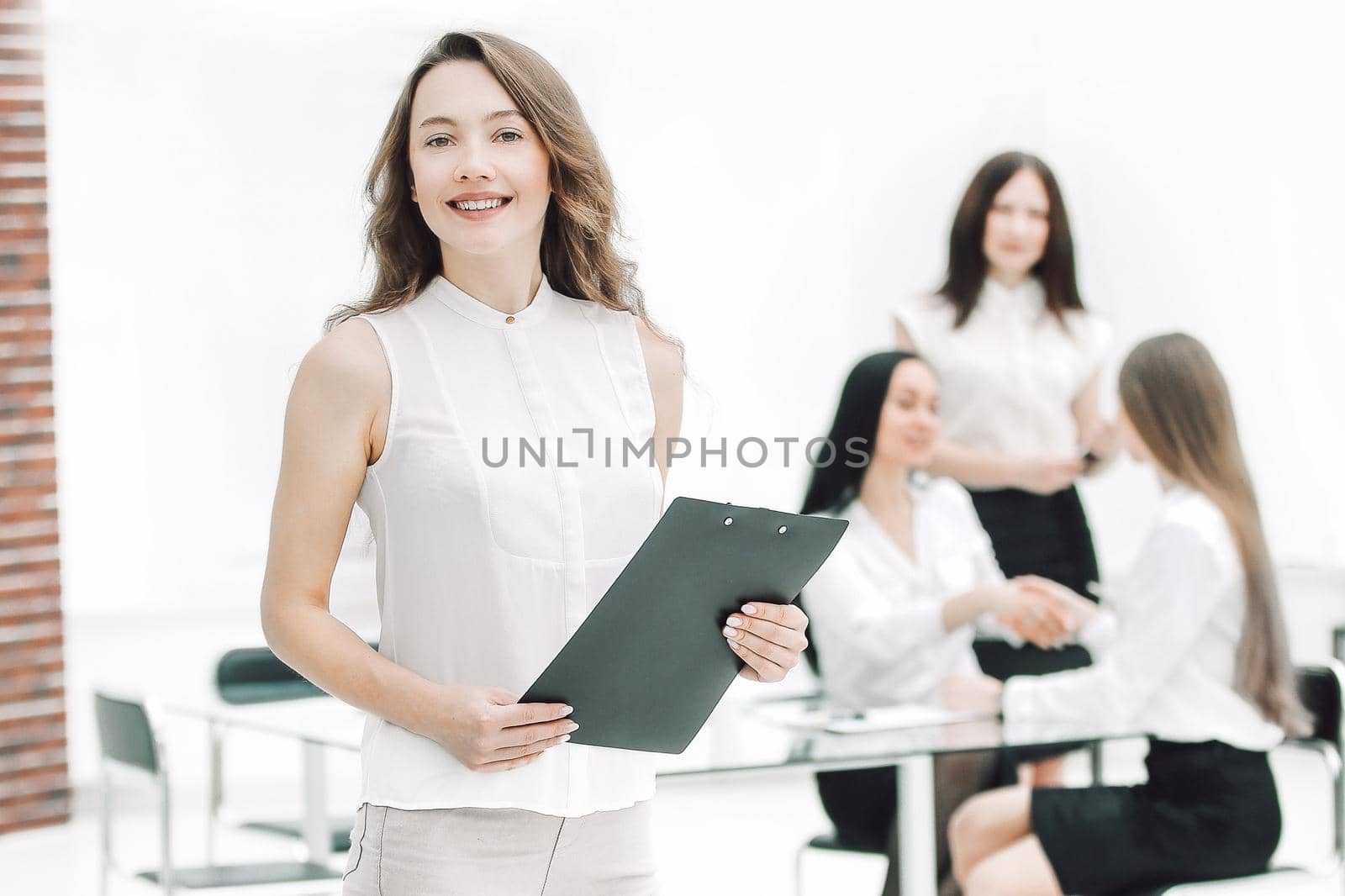 in full growth.successful business woman with clipboard on the background of business team.