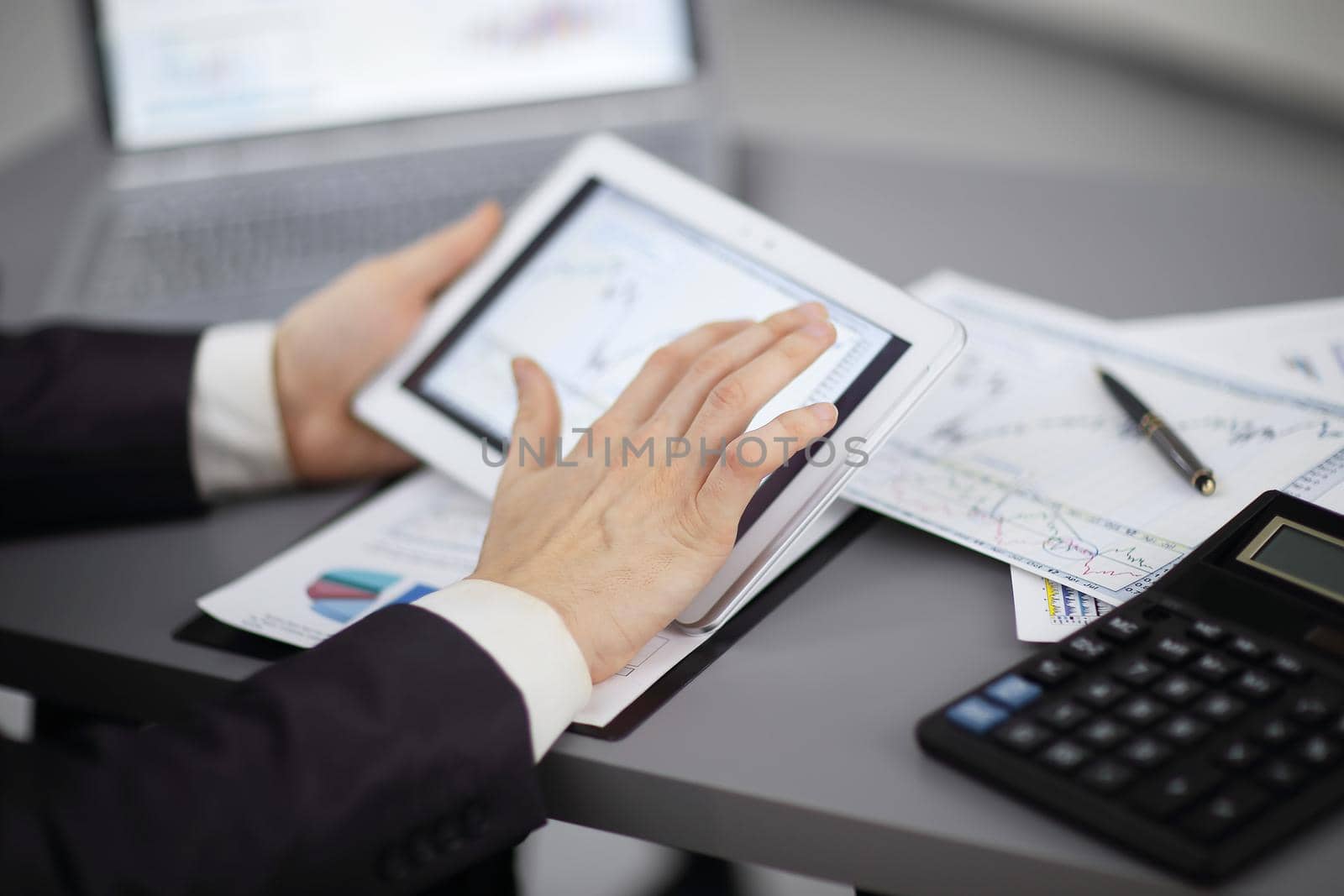close up.the businessman uses a digital tablet to work with financial data.