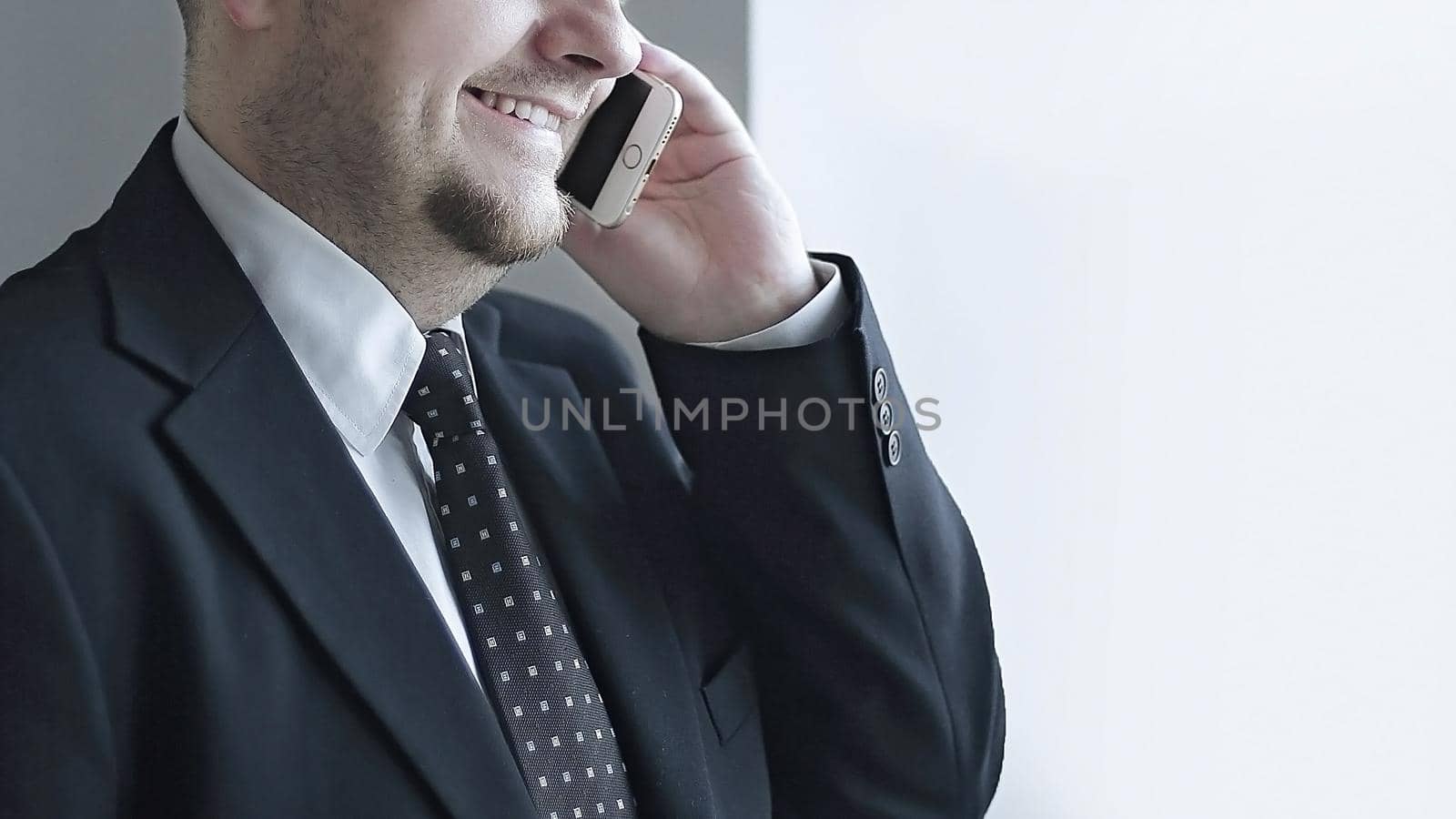 handsome pensive businessman using smartphoone and looking through window in the office.photo with copy space