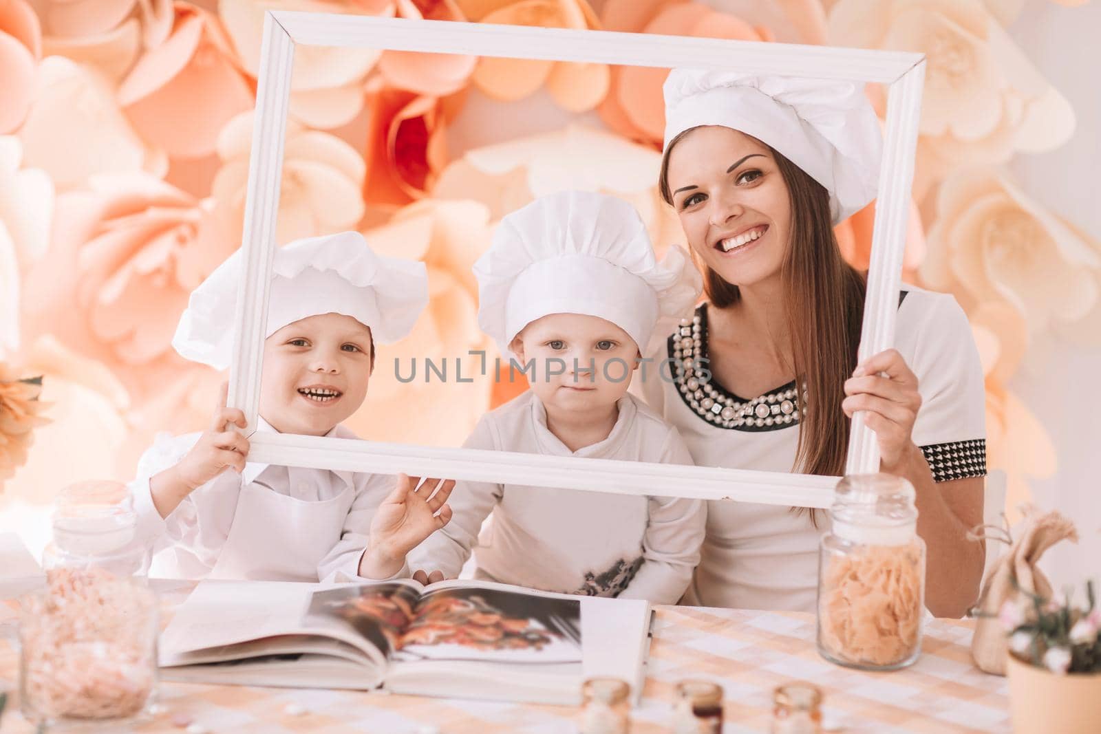 photo happy mom with children in the kitchen standing in front of the table . the concept of parenting