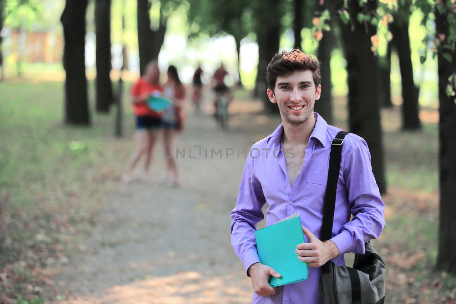 portrait of a successful student guy in a city Park.