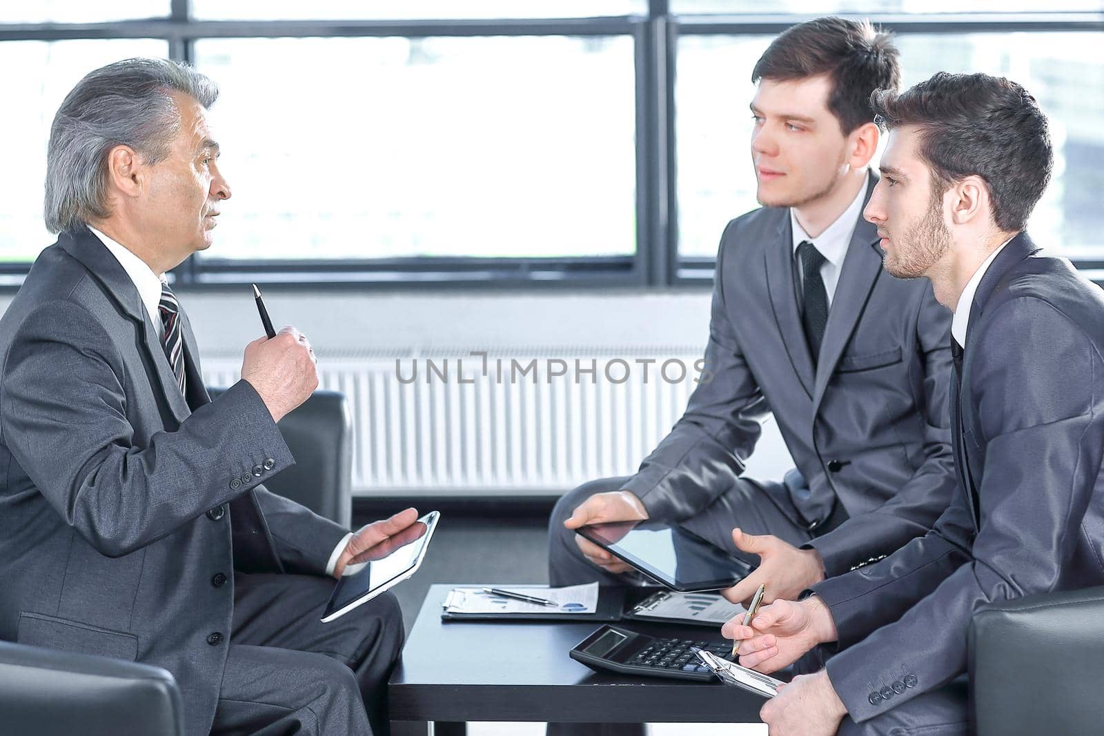 boss with a clipboard , sitting in an office.