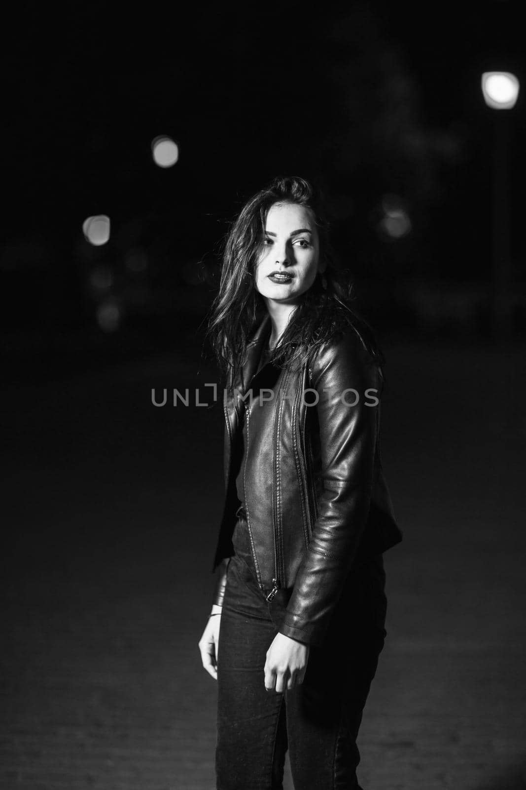 portrait of a stylish young woman, on the background of the city at night . city life