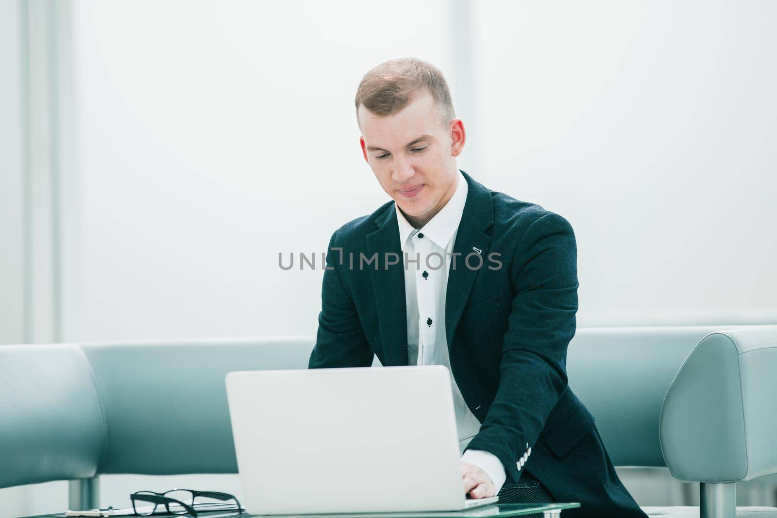 businessman working on a laptop in the lobby of a modern hotel. people and technology