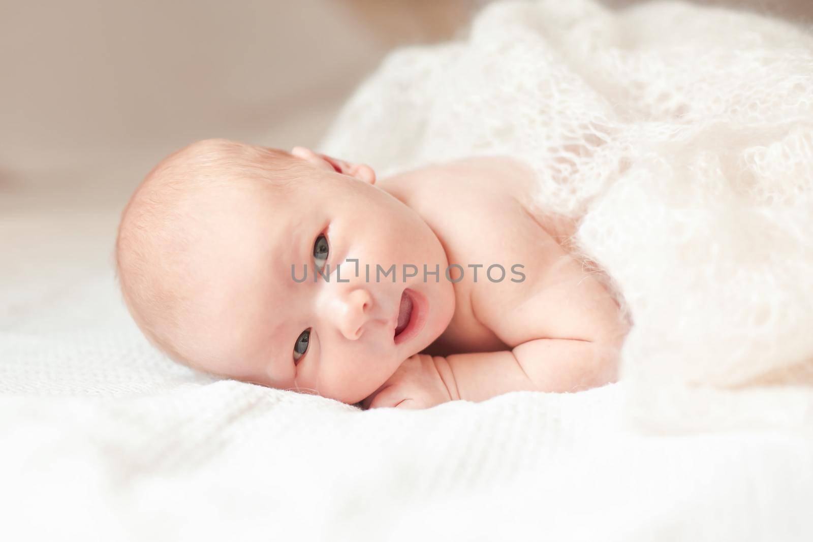 surprised newborn babe lying on the bed. photo with copy space