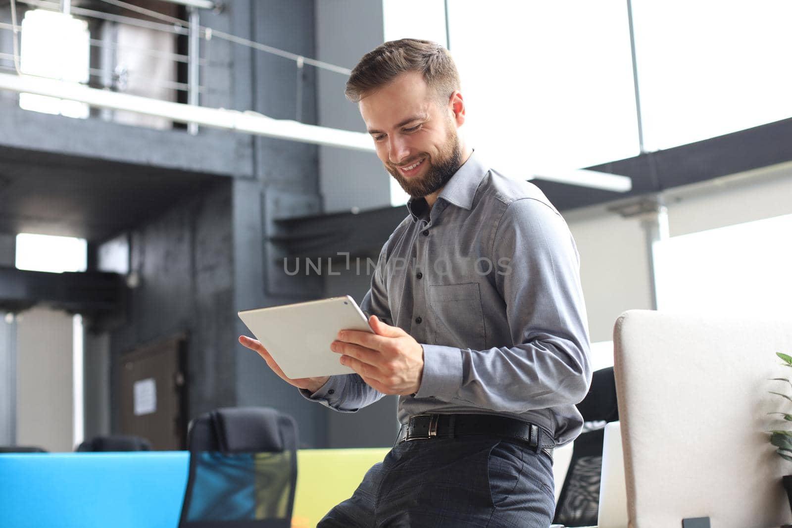 Young businessman using his tablet in the office