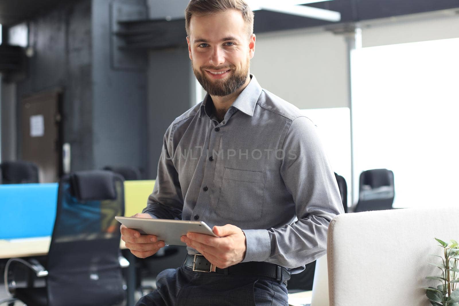 Young businessman using his tablet in the office