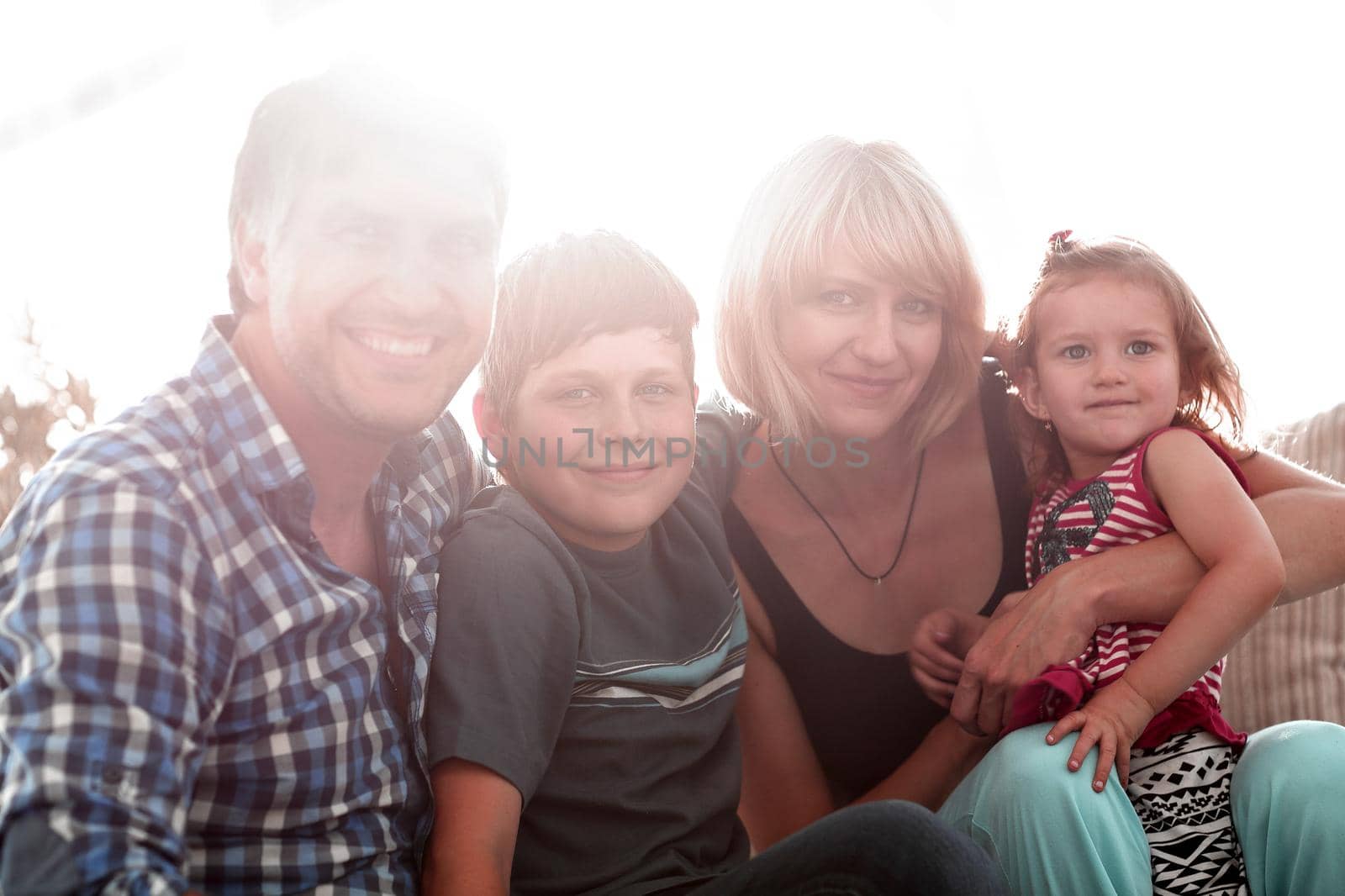 happy family mother, father and two children playing and cuddling at home