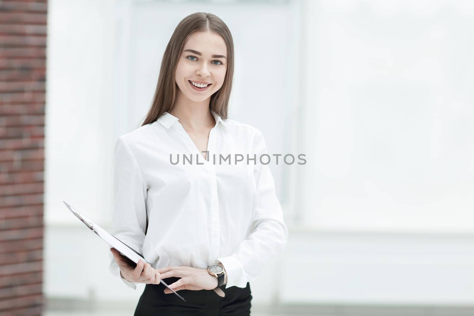 Executive business woman with clipboard against the background of bright office.