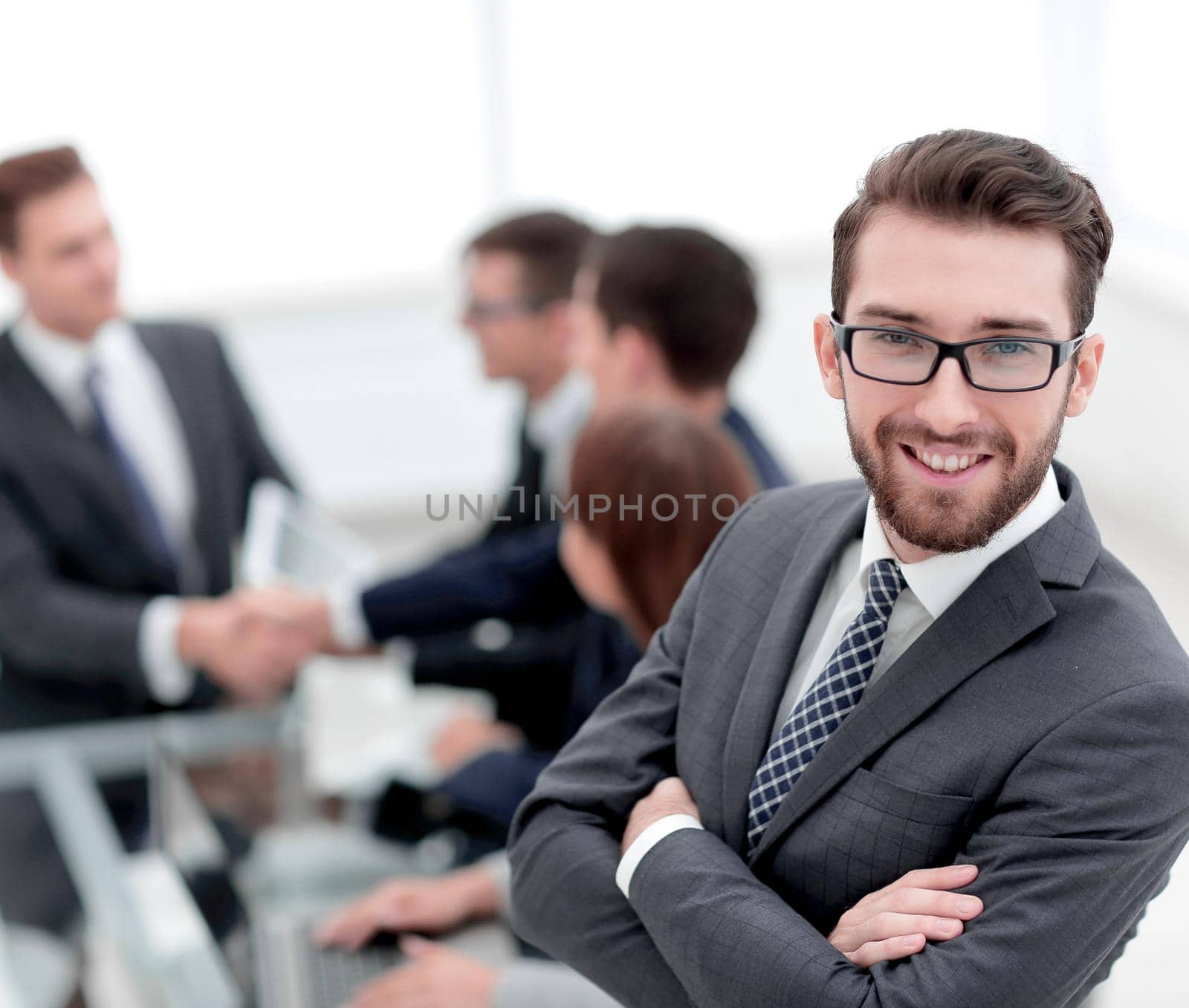 smiling businessman on background of office by asdf