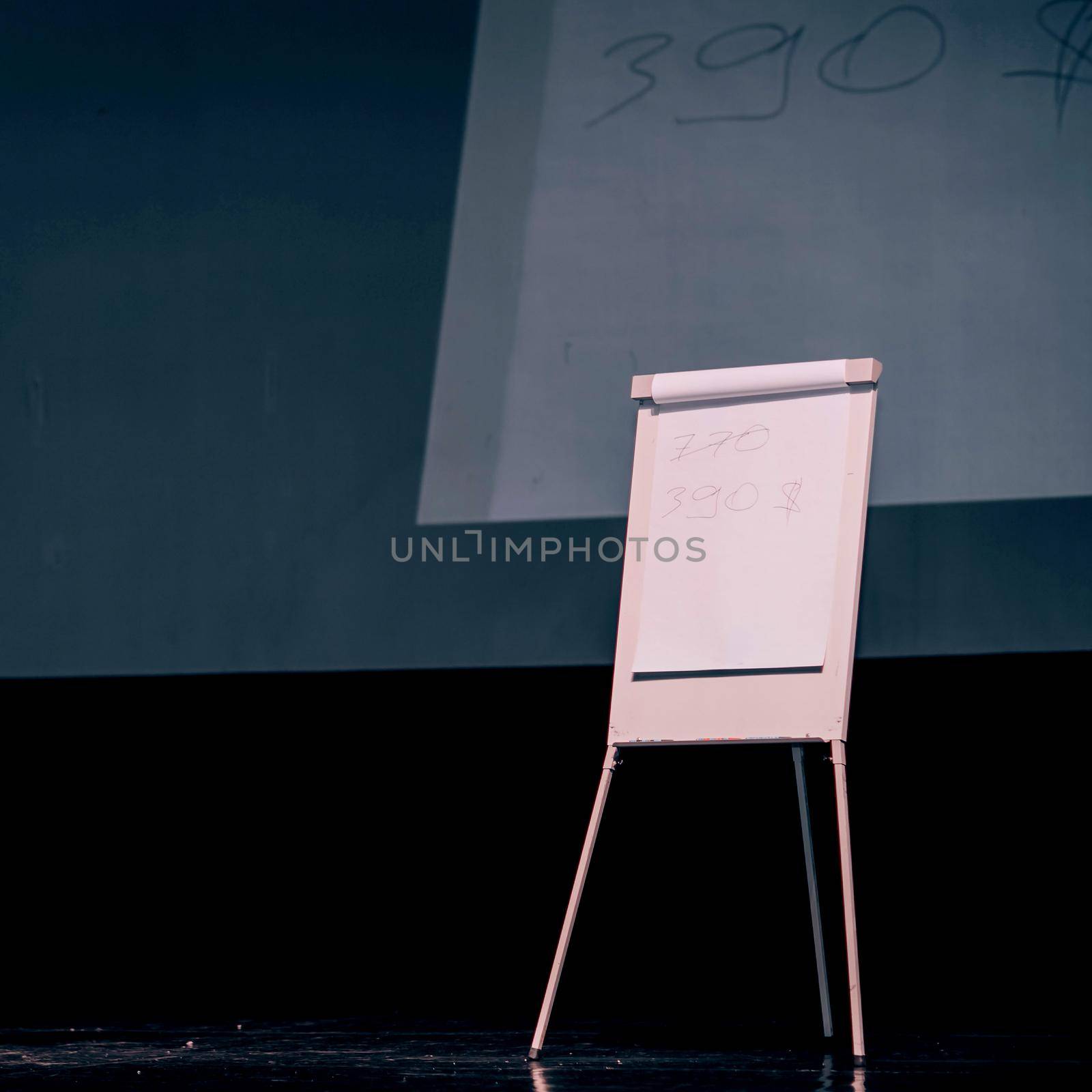 podium of the seminar with a flip chart and a large screen . photo with a copy of the space.