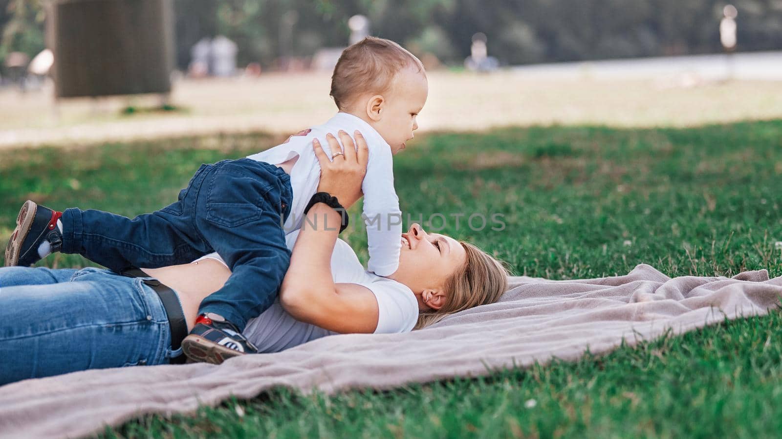 mom with her little son playing on the lawn on a summer day. the concept of a happy childhood