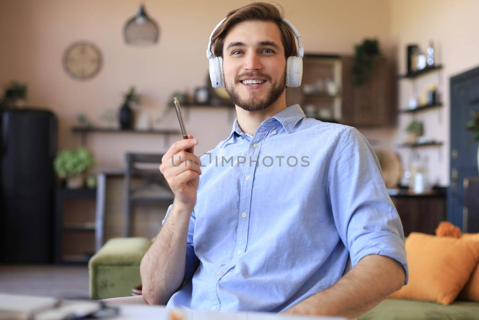 Happy young man in earphones working from home during self isolation