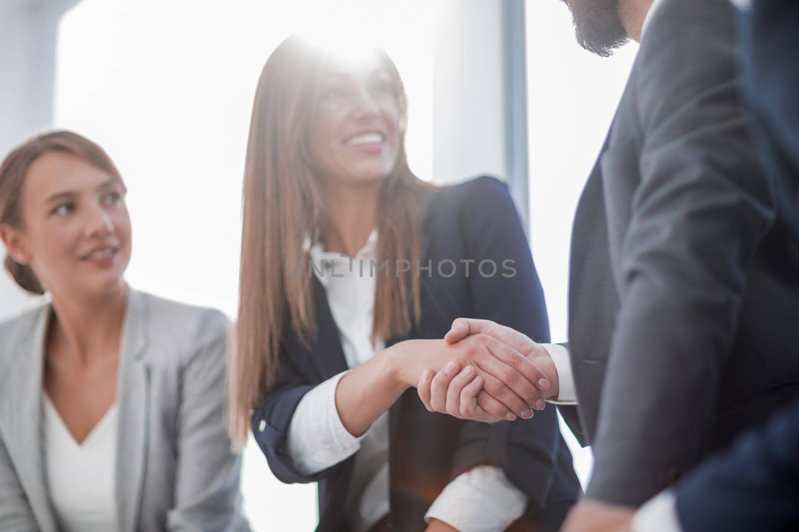 close up.smiling business woman shaking hands with partners by asdf
