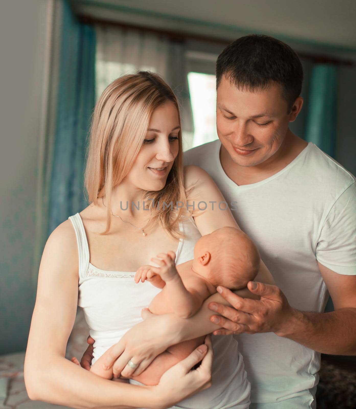 happy family with newborn baby standing in their apartment. photo with copy space