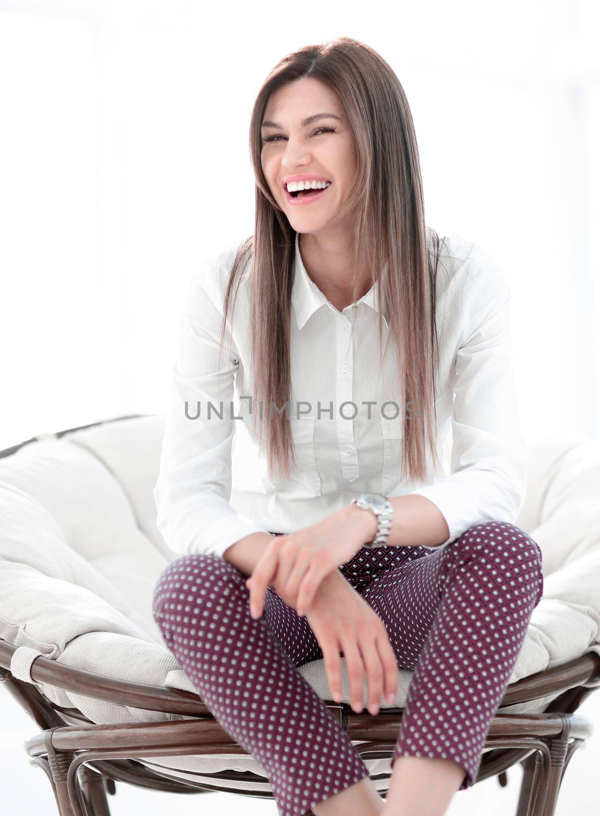 laughing young woman sitting in comfortable chair by asdf