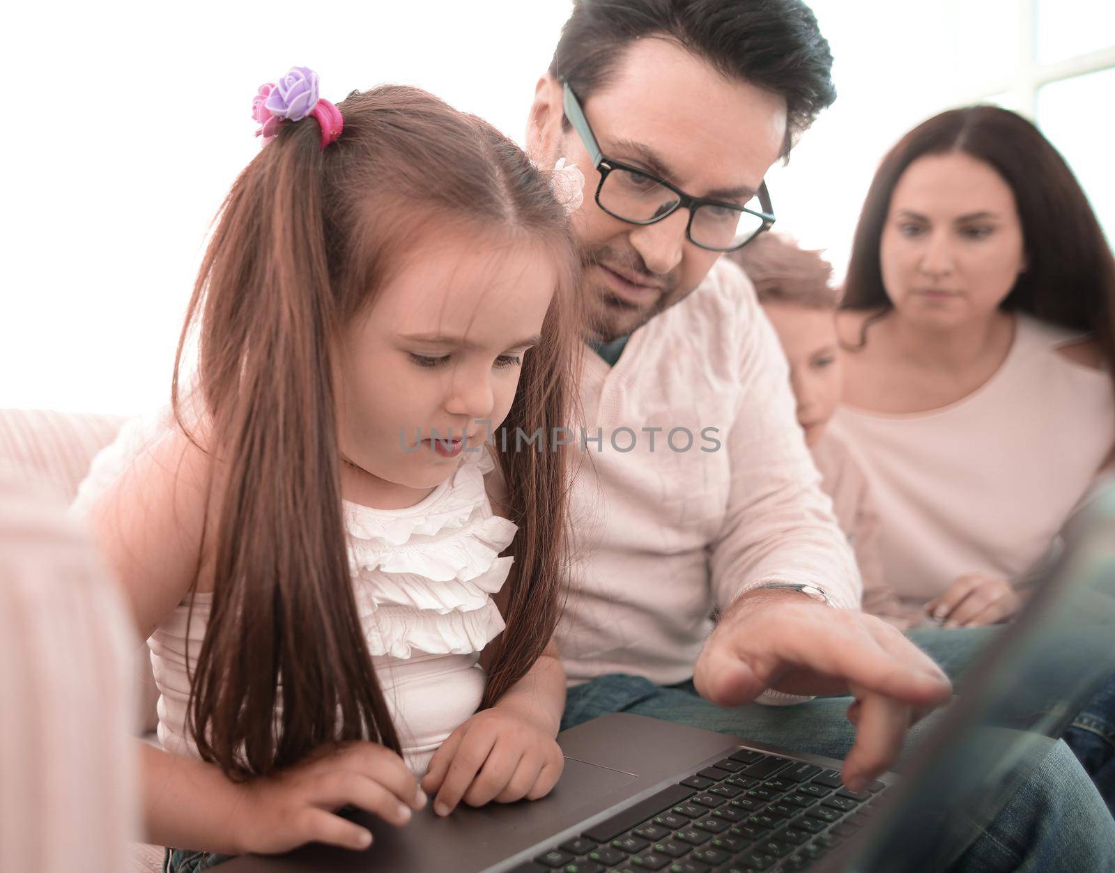 close up.dad teaches his daughter to use a laptop by asdf