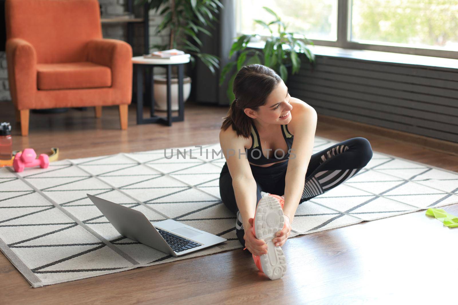 Fitness beautiful slim woman doing fitness stretching exercises at home in the living room. Stay at home activities. Sport, healthy lifestyle. by tsyhun