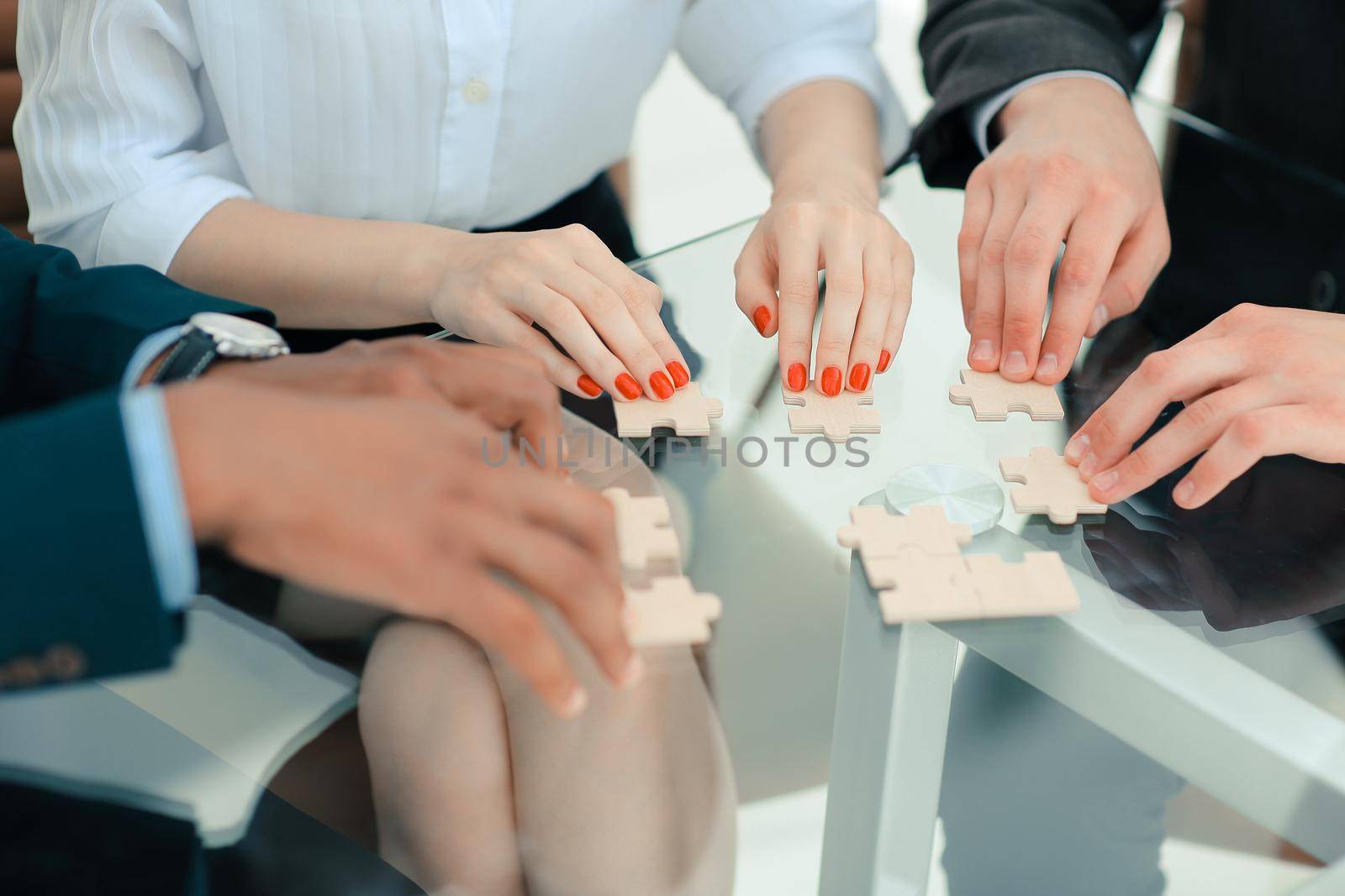 closeup. business team assembling puzzle pieces.concept business solutions