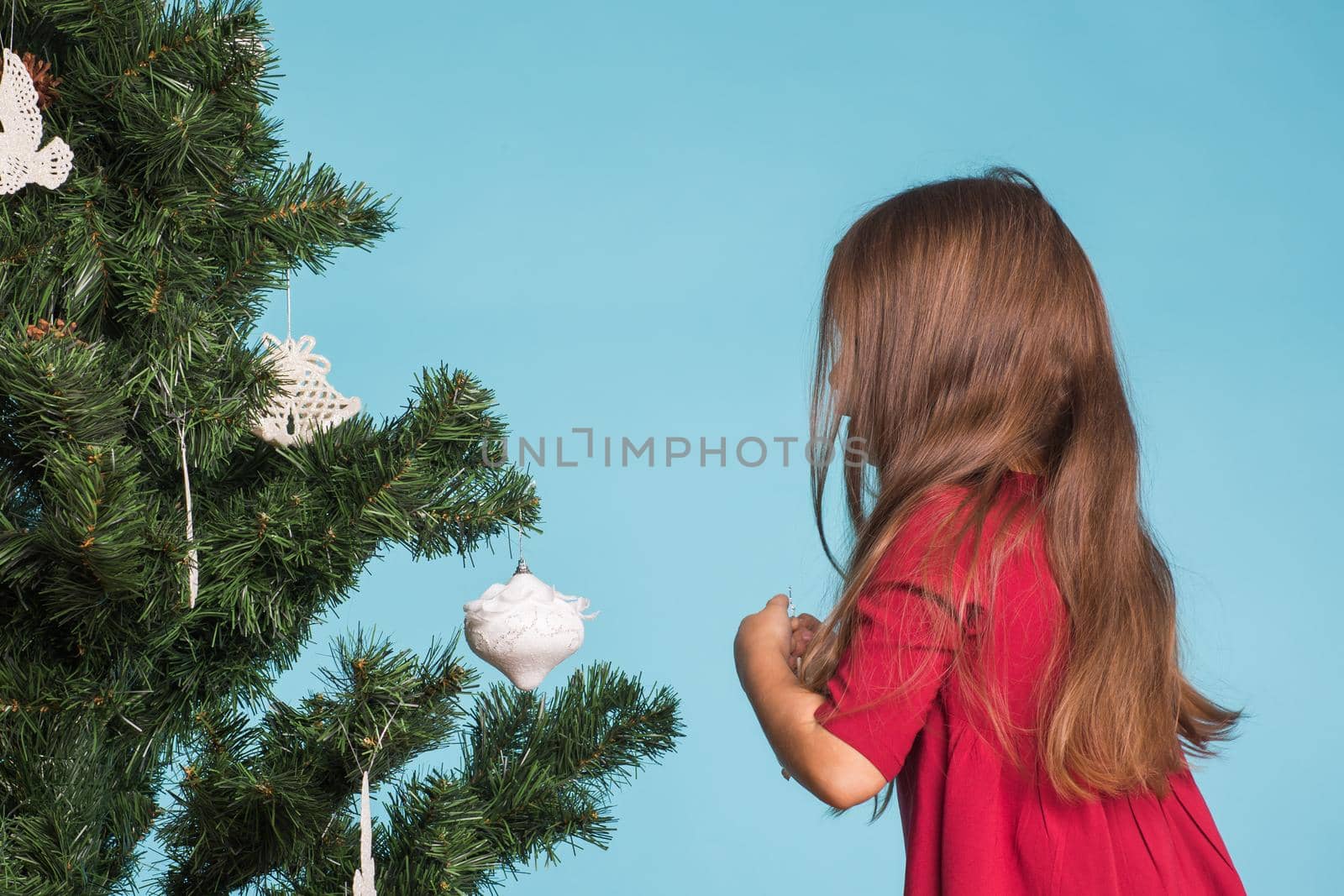 Christmas, childhood and people concept - little girl decorating the christmas tree by Satura86